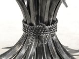 a close up of a metal vase with a knot around it
