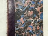un vieux livre posé sur une table recouverte de marbre