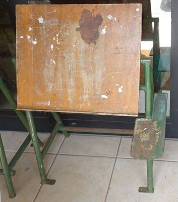une vieille table en bois avec un pied en métal, placée devant une porte