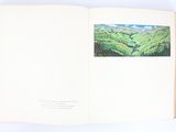 an open book with a picture of a mountain range