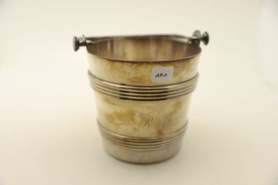 un seau à glace ancien en métal argenté, muni de poignées, sur fond blanc