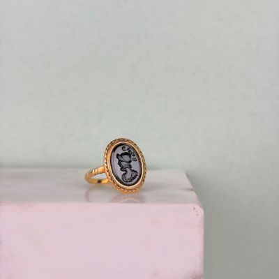 un gros plan d'une bague en or sur laquelle est sertie une pièce romaine