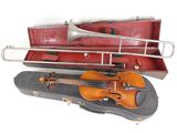 a violin and a trumpet in a case on a white surface
