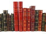 many books that are lined up together on a shelf