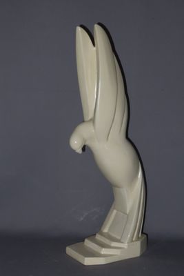 statue of a bird on a pedestal on a gray surface