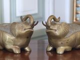 deux éléphants assis sur une table en bois, avec un miroir en arrière-plan