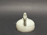 a small white figurine sitting on top of a table