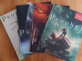 Trois livres sont posés sur une table dont le plateau est en bois.