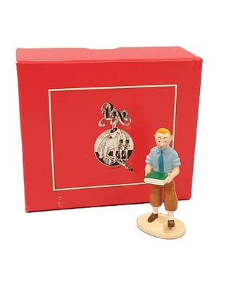 une figurine représentant un homme tenant un livre devant une boîte rouge