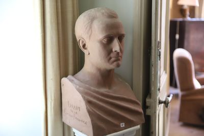 un buste d'homme assis devant une fenêtre
