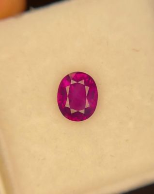 a close up of a pink sapphire stone on a white surface