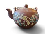 une théière marron ornée d'un motif représentant un oiseau
