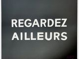 a close up of a black and white sign with the words regardez allieurs
