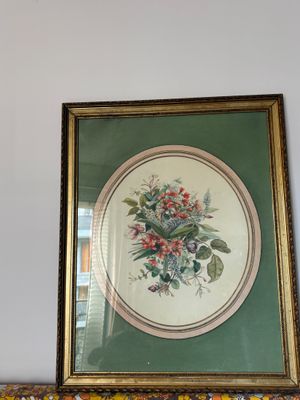 une photo d'un tableau représentant des fleurs posé sur une cheminée