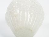 a white glass vase with a flower inside of it