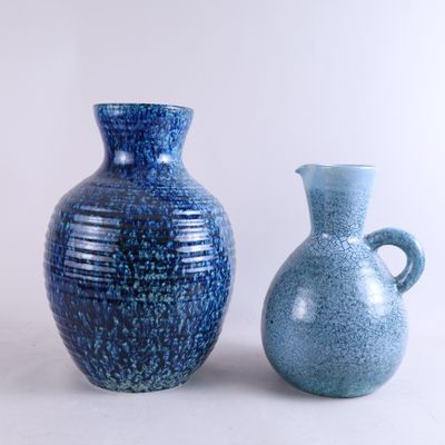 deux vases bleus posés l'un à côté de l'autre sur une table