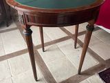 a small table with a green top on a tiled floor