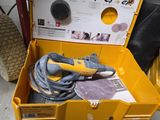 une boîte à outils jaune posée par terre, contenant des outils