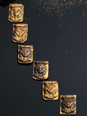 un gros plan sur une rangée de pièces d'or posées sur une surface noire