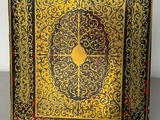 an ornate gold and black book with a clock on the cover