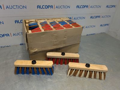 trois pinceaux en bois et une boîte de pinceaux rouges et bleus posés par terre