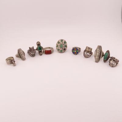 un ensemble de bagues en argent et d'autres bijoux posés sur une surface blanche