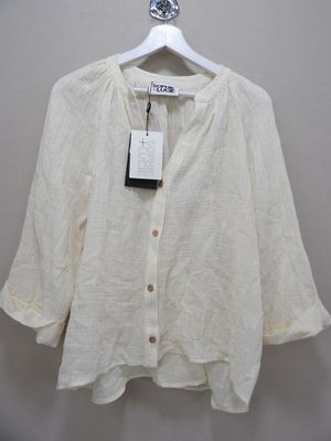 a white shirt hanging on a hanger on a wall