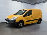 La camionnette jaune est garée dans une grande pièce aux murs blancs.