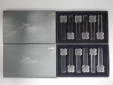 quatre boîtes argentées et noires contenant un lot de cinq brosses à dents en verre