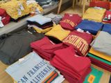 une pile de t-shirts par terre dans une pièce