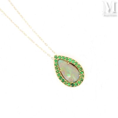 a close up of a necklace with an oplite and emerald pendant