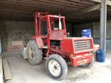a red tractor that is parked in a garage