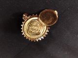 a close up of a gold locke with a coin inside of it