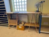 a desk with a fan and shelves in a room