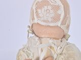a doll that is wearing a white dress and a hat