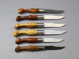 six knives are lined up in a row on a table