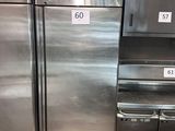 des réfrigérateurs en acier inoxydable dans une cuisine professionnelle, avec des étiquettes de prix dessus