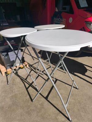 des tables et des chaises dans un parking, avec une camionnette rouge en arrière-plan