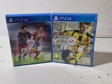 two video games are sitting on a white surface, one is a soccer game and the other is a video game