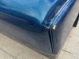 blue leather couch sitting on top of a wooden floor next to a blue chair