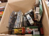 une boîte en carton remplie de petits trains et d'autres jouets