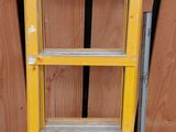 une échelle jaune appuyée contre un mur en bois