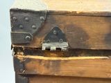 une vieille malle en bois munie d'un loquet métallique