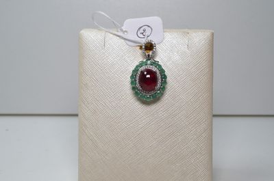 un gros plan d'un collier orné d'une pierre rouge