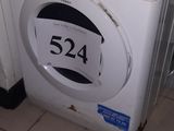 une machine à laver posée dans un coin de la pièce