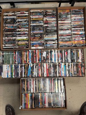 a lot of dvd ' s in a box on the floor