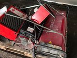 a red machine sitting on top of a wooden pallet