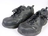 une paire de chaussures noires à lacets posée sur une surface blanche