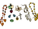 many different necklaces and earrings on a white surface