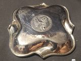 a silver plate with a lion on it on a table
